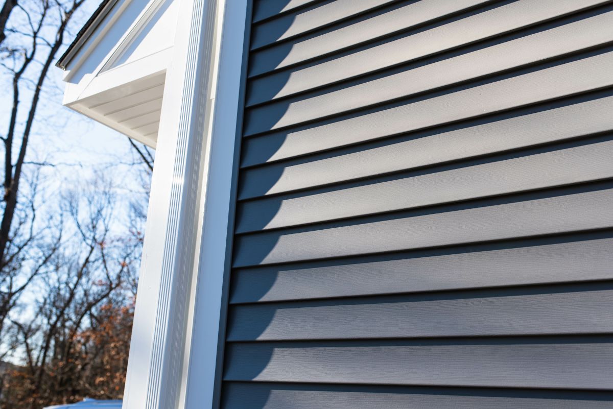 Details of gutters and dark vinyl siding on residential home